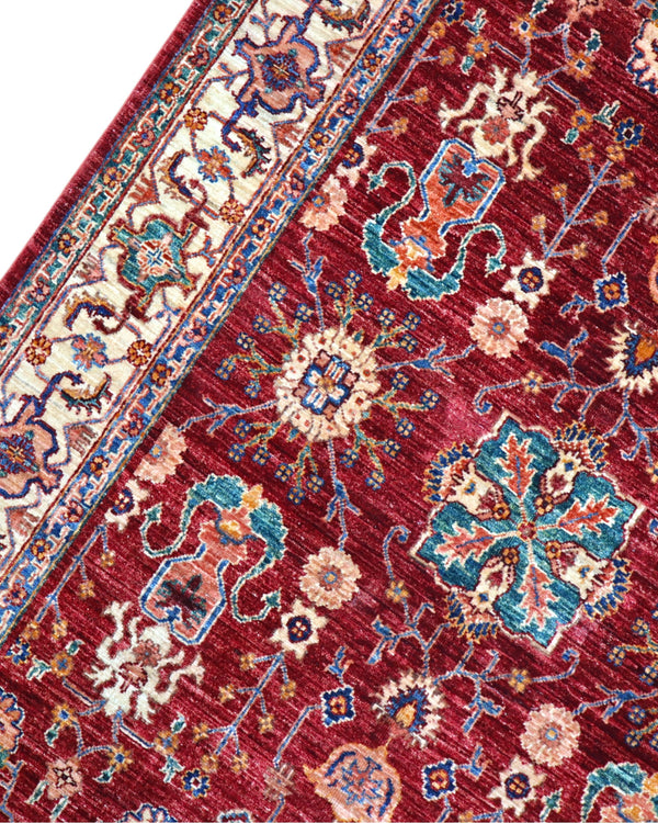 Tappeto Farahan 176x127 cm con motivi floreali e geometrici in rosso, blu, verde e oro su fondo beige.