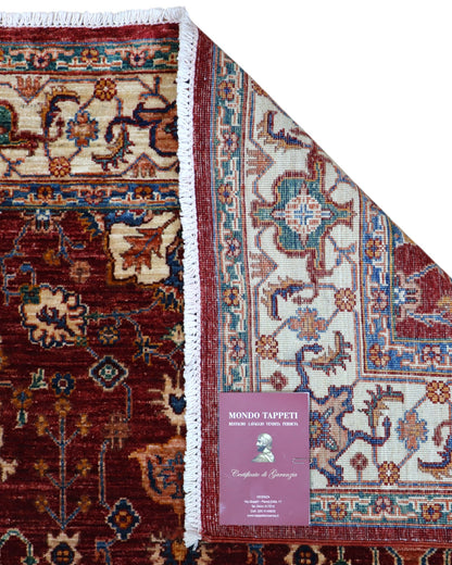 Tappeto Farahan 176x127 cm con motivi floreali e geometrici in rosso, blu, verde e oro su fondo beige.