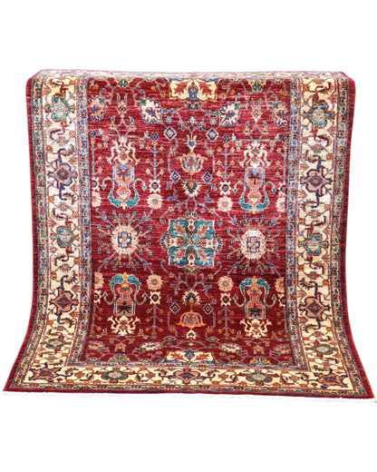 Tappeto Farahan 176x127 cm con motivi floreali e geometrici in rosso, blu, verde e oro su fondo beige.