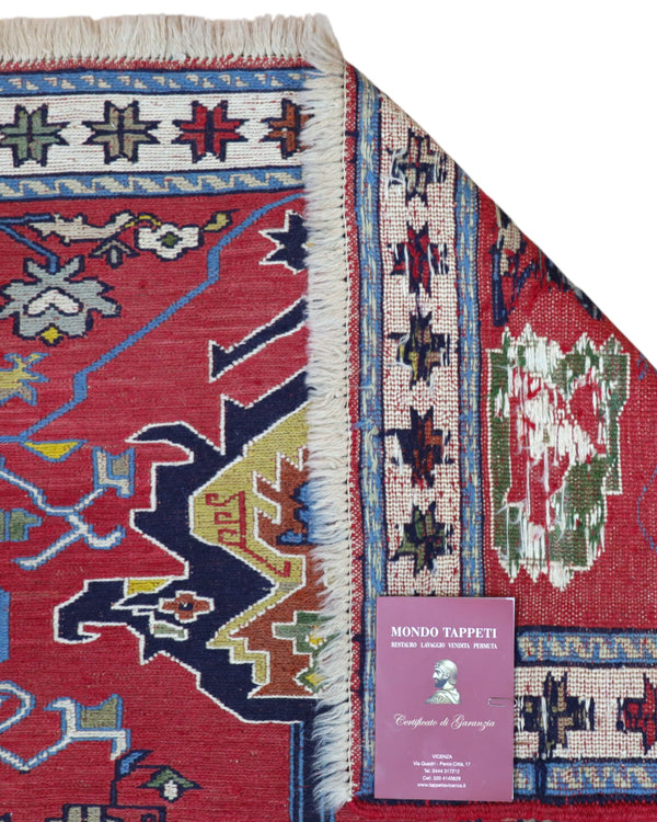 Tappeto Kilim 190x122 cm con motivi geometrici in rosso, blu, giallo e verde su fondo beige.