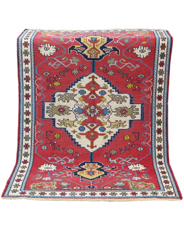 Tappeto Kilim 190x122 cm con motivi geometrici in rosso, blu, giallo e verde su fondo beige.