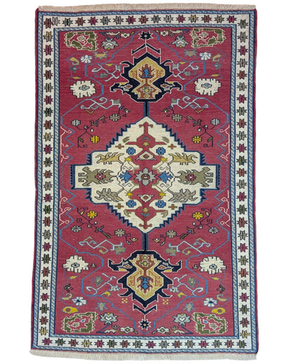 Tappeto Kilim 190x122 cm con motivi geometrici in rosso, blu, giallo e verde su fondo beige.