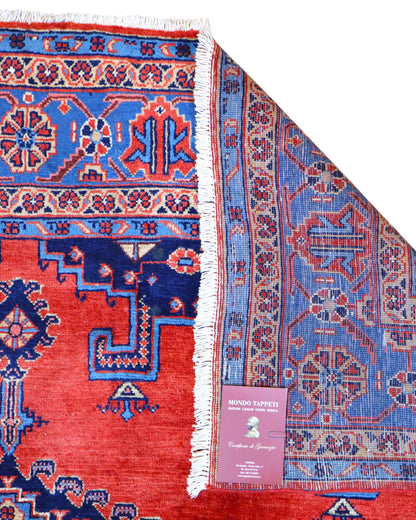 Tappeto Heriz persiano 339x219 cm, annodato a mano su telaio tradizionale, lana e cotone con colori vegetali, fondo rosso e dettagli blu.