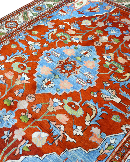 Tappeto Heriz 240x320 cm persiano annodato a mano con fondo rosso e dettagli azzurri e avorio.