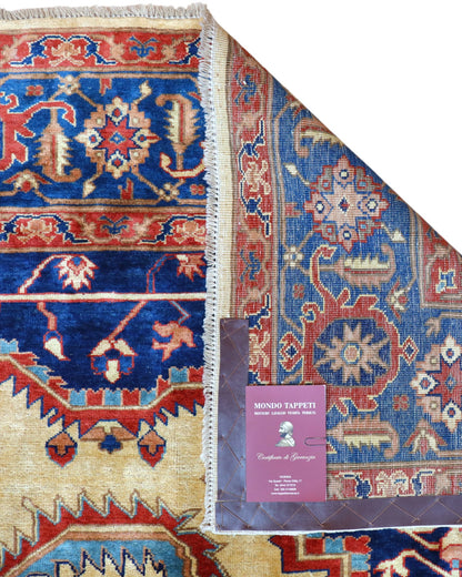 Tappeto Heriz persiano 303x255 cm, annodato a mano, lana e cotone con colori vegetali, fondo avorio con medaglione rosso e dettagli blu.