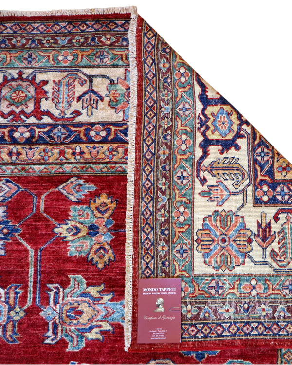 Tappeto Kazak 445x307 cm afghano, annodato a mano, con fondo rosso e motivi geometrici in azzurro, avorio e oro.