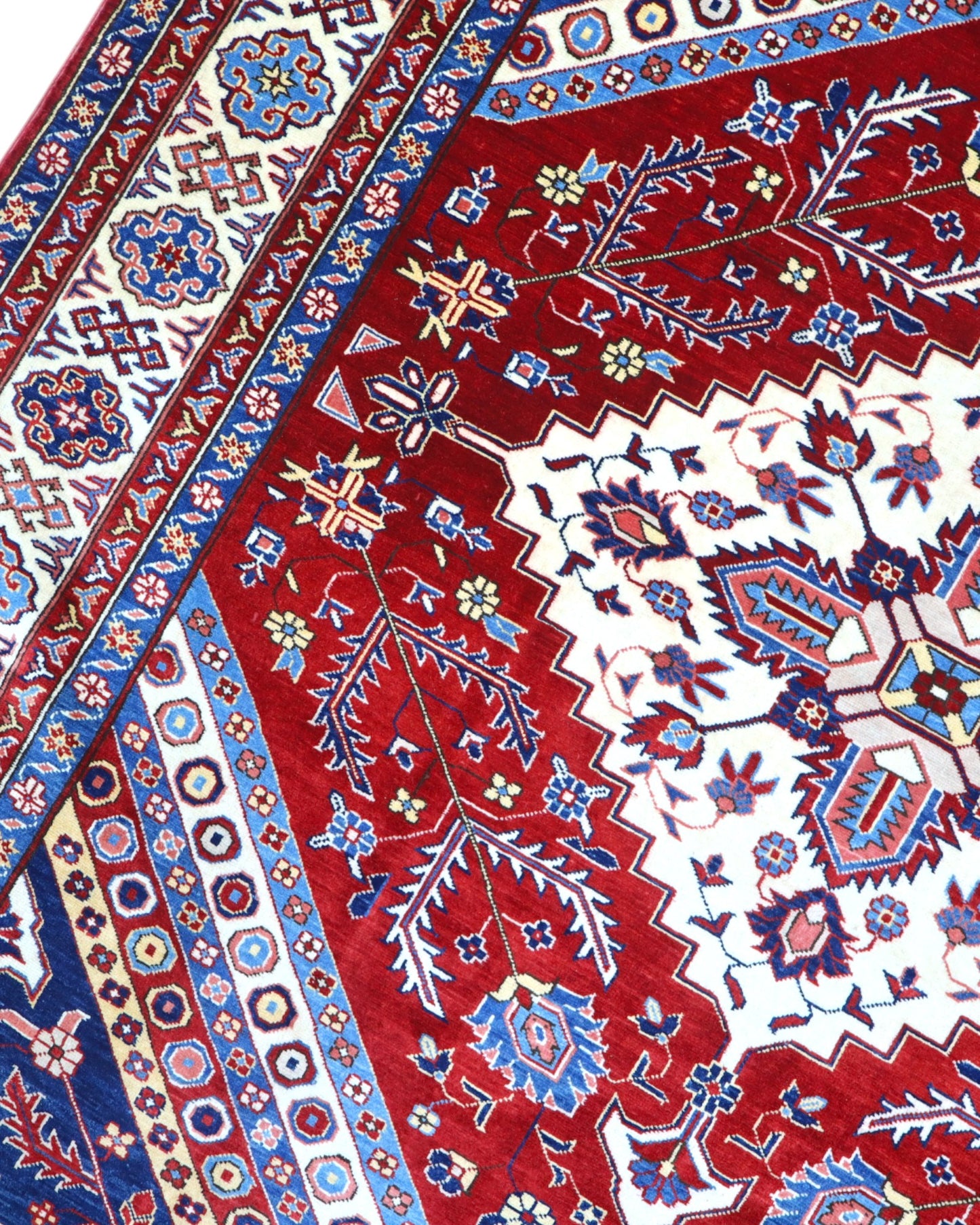 Tappeto Shirvan 274x184 cm con fondo rosso, medaglione centrale blu e avorio e bordure geometriche multicolori, tramato ed annodato a mano.