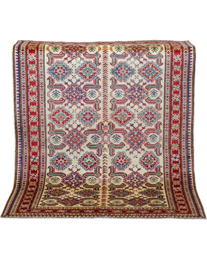 Tappeto Shirvan 165x122 cm con motivi geometrici e floreali in rosso, blu, verde e crema su fondo beige.