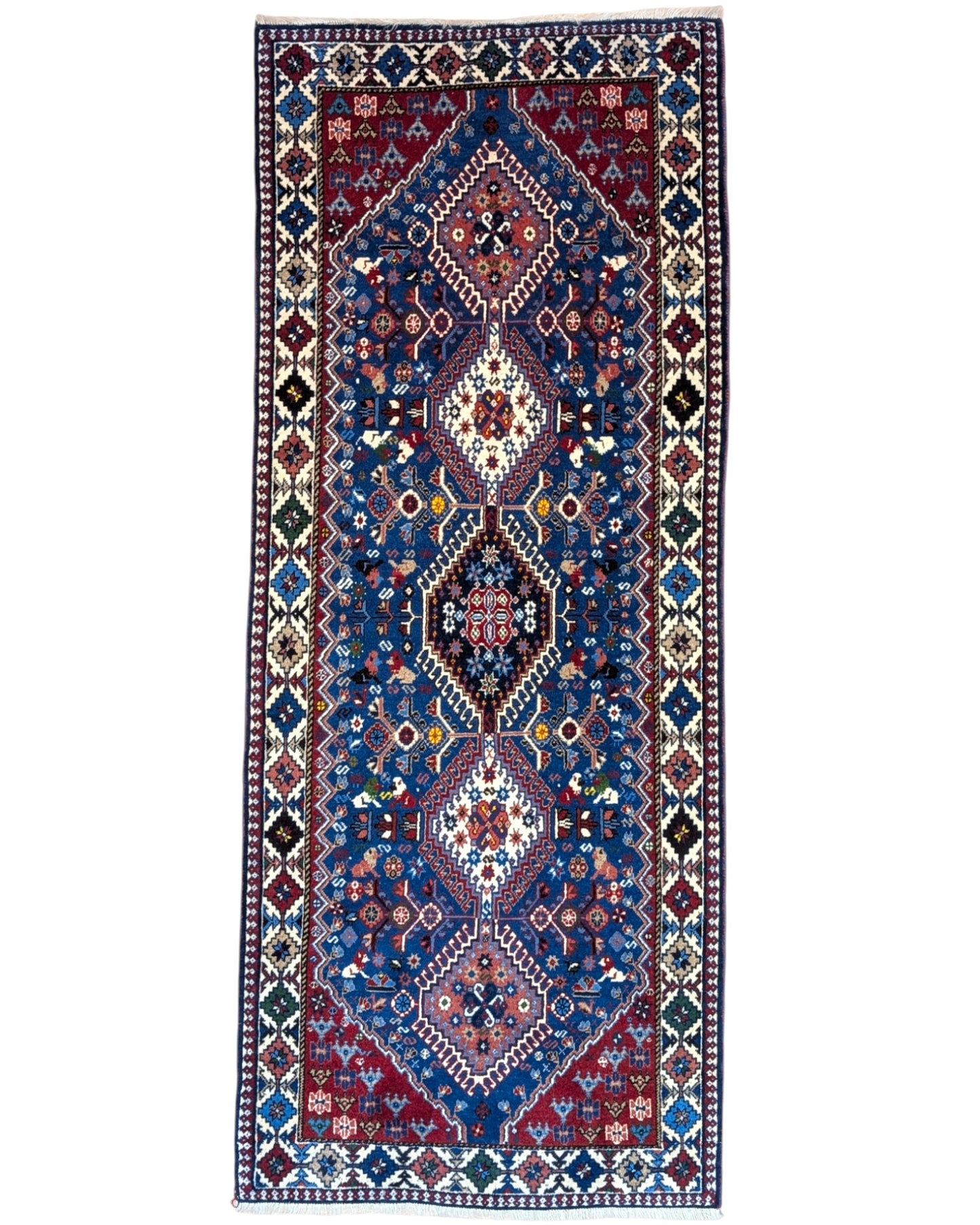 Tappeto persiano Yalameh 204x82 cm, corridore con fondo blu intenso e motivi geometrici rossi, avorio e verdi, annodato a mano in lana vegetale.