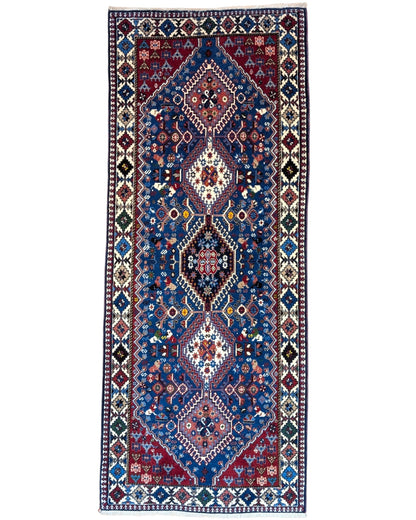 Tappeto persiano Yalameh 204x82 cm, corridore con fondo blu intenso e motivi geometrici rossi, avorio e verdi, annodato a mano in lana vegetale.