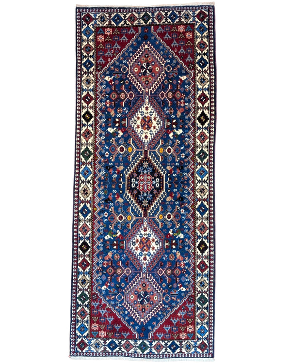 Tappeto persiano Yalameh 204x82 cm, corridore con fondo blu intenso e motivi geometrici rossi, avorio e verdi, annodato a mano in lana vegetale.