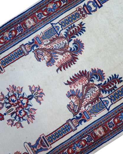 Tappeto Sarough persiano 205x82 cm, corridore con fondo avorio e motivi floreali in blu e rosso, annodato a mano in lana vegetale.