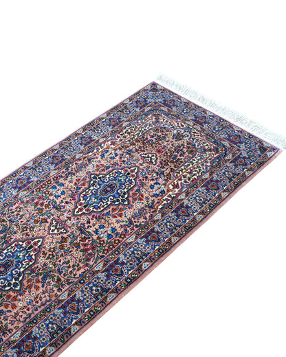Tappeto persiano Kerman 247x77 cm, corridore con fondo rosa antico e motivi floreali blu e avorio, annodato a mano in lana vegetale.