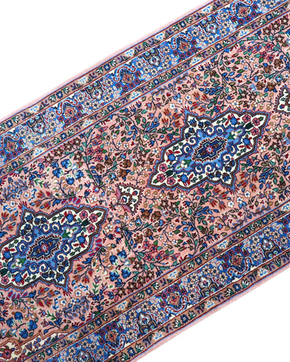 Tappeto persiano Kerman 247x77 cm, corridore con fondo rosa antico e motivi floreali blu e avorio, annodato a mano in lana vegetale.