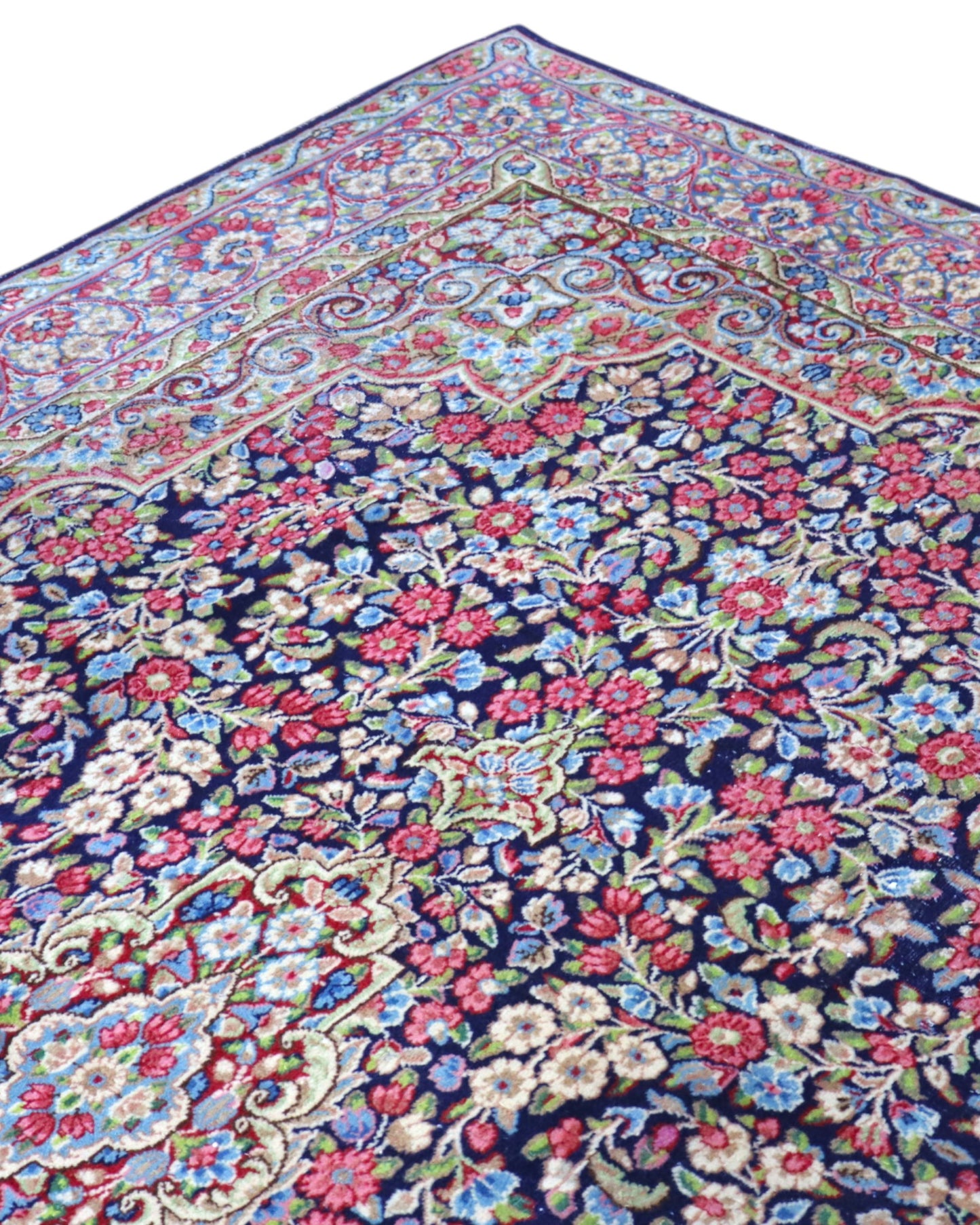 Tappeto Kerman 296x197 cm con fondo blu notte e motivi floreali rosa, avorio e verde, tramato ed annodato a mano, provenienza Kerman.