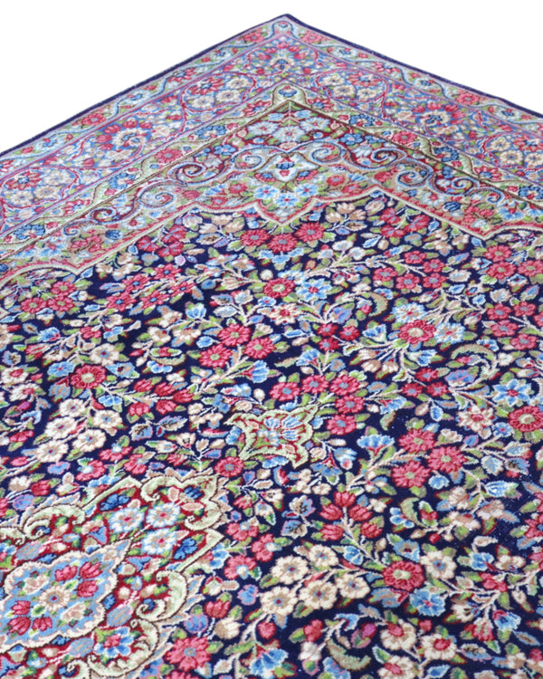 Tappeto Kerman 296x197 cm con fondo blu notte e motivi floreali rosa, avorio e verde, tramato ed annodato a mano, provenienza Kerman.