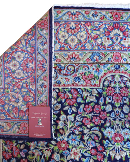 Tappeto Kerman 296x197 cm con fondo blu notte e motivi floreali rosa, avorio e verde, tramato ed annodato a mano, provenienza Kerman.
