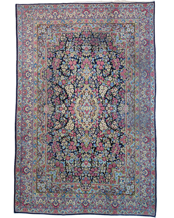 Tappeto Kerman 296x197 cm con fondo blu notte e motivi floreali rosa, avorio e verde, tramato ed annodato a mano, provenienza Kerman.