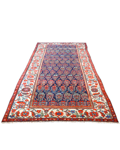 Tappeto Malayer antico 350x176 cm con fondo blu scuro, motivi geometrici rossi e avorio e bordura floreale vivace, tramato ed annodato a mano, provenienza Persia.