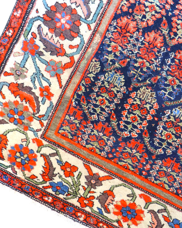 Tappeto Malayer antico 350x176 cm con fondo blu scuro, motivi geometrici rossi e avorio e bordura floreale vivace, tramato ed annodato a mano, provenienza Persia.