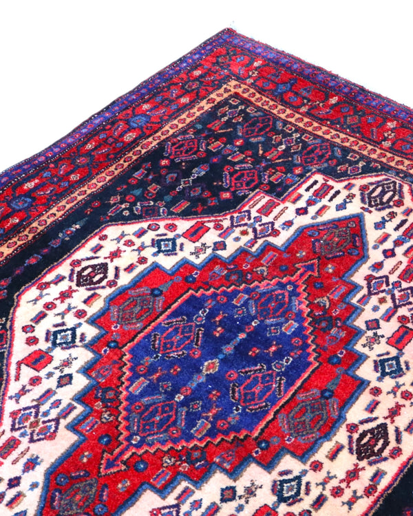 Tappeto Sanneh geometrico blu e rosso 160x134 cm in camera da letto