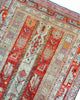 Tappeto Caucaso Antico 183x112 cm in lana con motivi tribali e bordure decorative su fondo rosso.