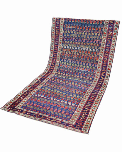 Tappeto Caucaso Antico 266x136 cm con piccoli motivi ripetuti e bordure ornamentali nei toni del blu e avorio.