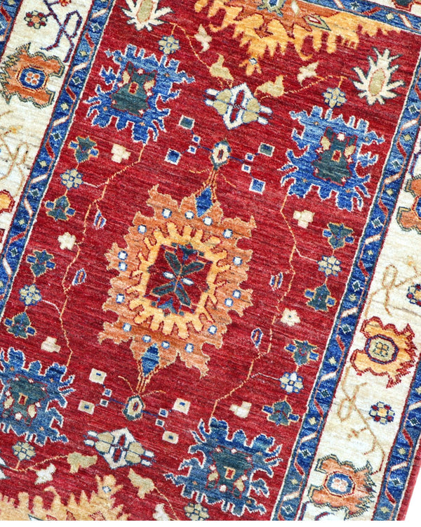 Tappeto Farahan geometrico rosso 159x106 cm in camera da letto