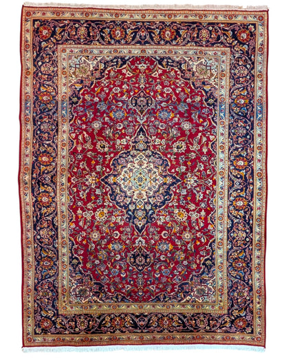 Tappeto persiano Kashan 238x247cm con fondo rosso, medaglione avorio e ricchi motivi floreali blu e oro.