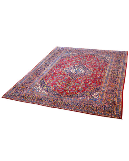 Tappeto persiano Kashan 400x290 cm, fondo rosso con medaglione centrale blu e avorio, cornice scura floreale, annodato a mano in lana vegetale.