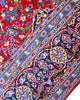 Tappeto persiano Kashan 402x297 cm, fondo rosso con medaglione centrale blu e avorio, annodato a mano in lana vegetale.