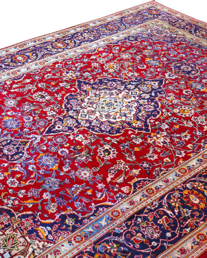 Tappeto persiano Kashan 238x247cm con fondo rosso, medaglione avorio e ricchi motivi floreali blu e oro.