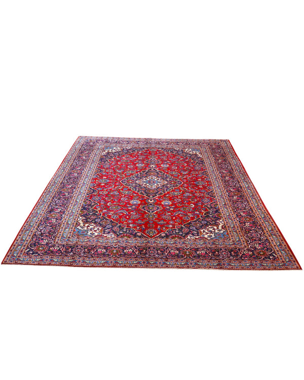 Tappeto persiano Kashan 402x297 cm, fondo rosso con medaglione centrale blu e avorio, annodato a mano in lana vegetale.
