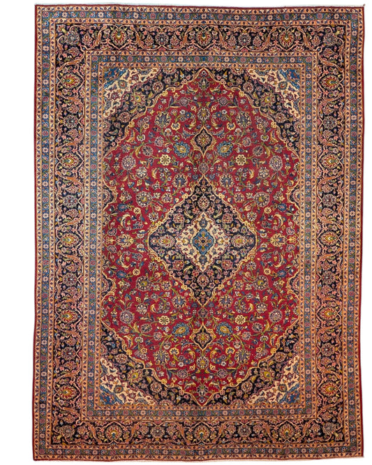 Tappeto persiano Kashan 400x290 cm, fondo rosso con medaglione centrale blu e avorio, cornice scura floreale, annodato a mano in lana vegetale.