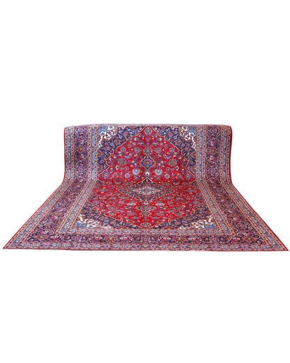Tappeto persiano Kashan 402x297 cm, fondo rosso con medaglione centrale blu e avorio, annodato a mano in lana vegetale.