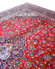 Tappeto persiano Kashan 402x297 cm, fondo rosso con medaglione centrale blu e avorio, annodato a mano in lana vegetale.