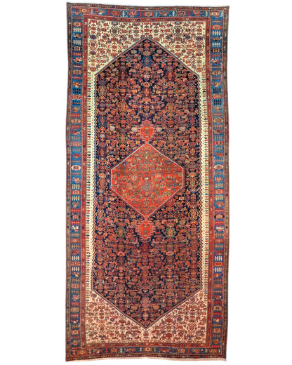 Tappeto persiano Malayer 390x297 cm, fondo blu con medaglione geometrico rosso, estremità avorio e cornice floreale, annodato a mano in lana vegetale.