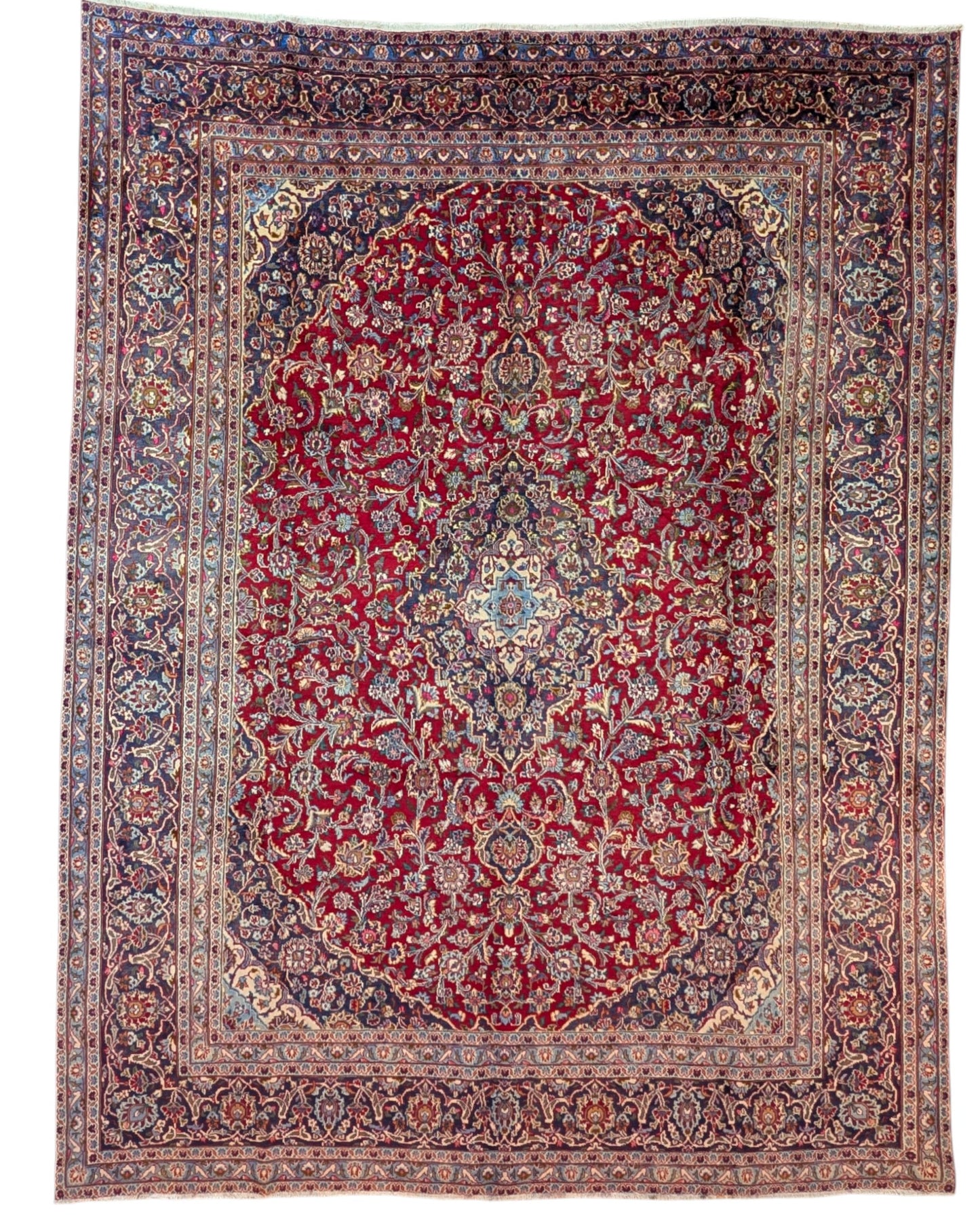 Tappeto persiano Mashhad 385x290 cm, fondo rosso con medaglione centrale e cornice floreale blu e beige, annodato a mano in lana vegetale.