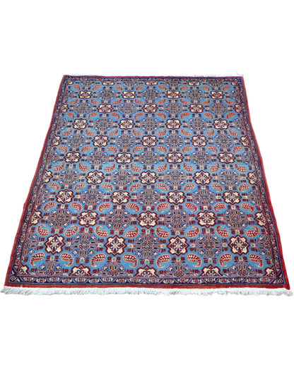 Tappeto Najafabad azzurro 151x107 cm con disegni floreali in salotto