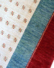 Tappeto 270x185 cm blu petrolio e avorio con cornice rossa per ingresso ampio.