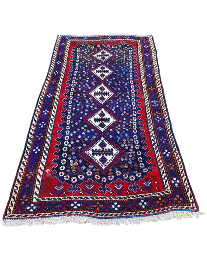 Tappeto Balucestan 215x100 cm annodato a mano, con sequenza di rombi centrali su fondo blu notte e bordi rosso granata.