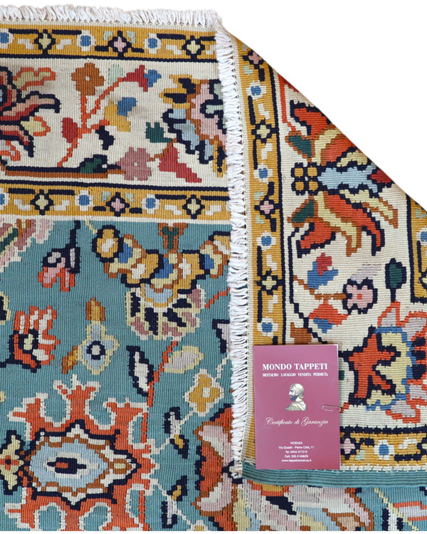 Tappeto Kilim Turco 290x200 cm con fondo azzurro, motivi floreali e geometrici multicolori, tramato ed annodato a mano.