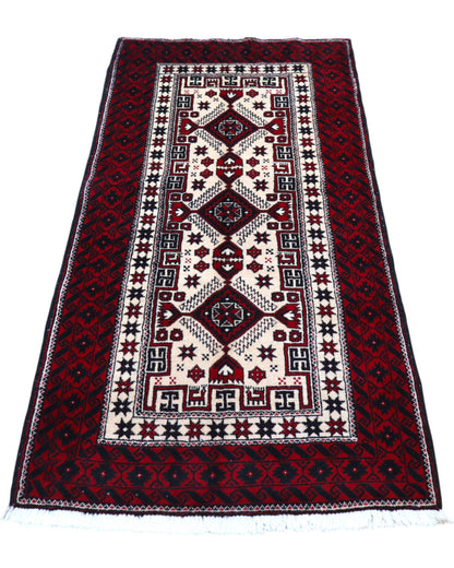 "Tappeto Balochistan 187x95 cm annodato a mano, fondo avorio con motivi geometrici rossi, neri e verdi."
