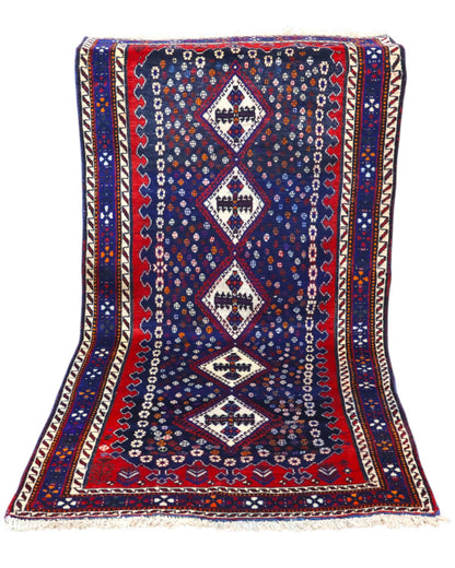 Tappeto Balucestan 215x100 cm annodato a mano, con sequenza di rombi centrali su fondo blu notte e bordi rosso granata.