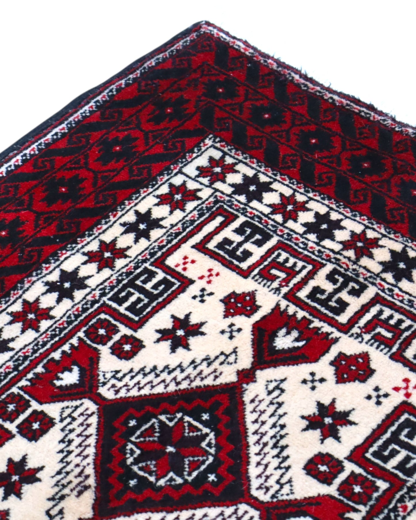 "Tappeto Balochistan 187x95 cm annodato a mano, fondo avorio con motivi geometrici rossi, neri e verdi."
