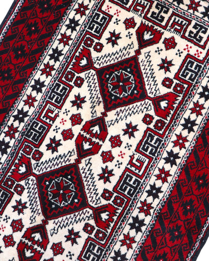 "Tappeto Balochistan 187x95 cm annodato a mano, fondo avorio con motivi geometrici rossi, neri e verdi."
