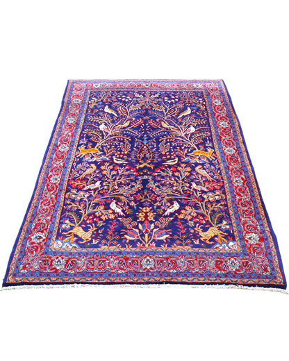Tappeto Arak 210x126 cm persiano annodato a mano, con motivi floreali e animali su fondo blu intenso e cornice rossa decorata.