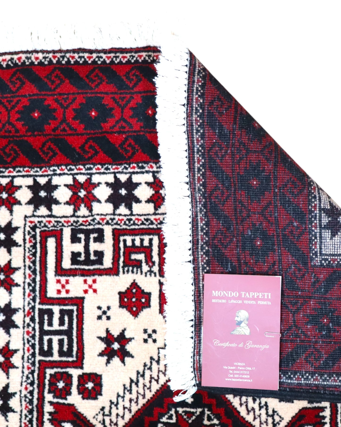 "Tappeto Balochistan 187x95 cm annodato a mano, fondo avorio con motivi geometrici rossi, neri e verdi."
