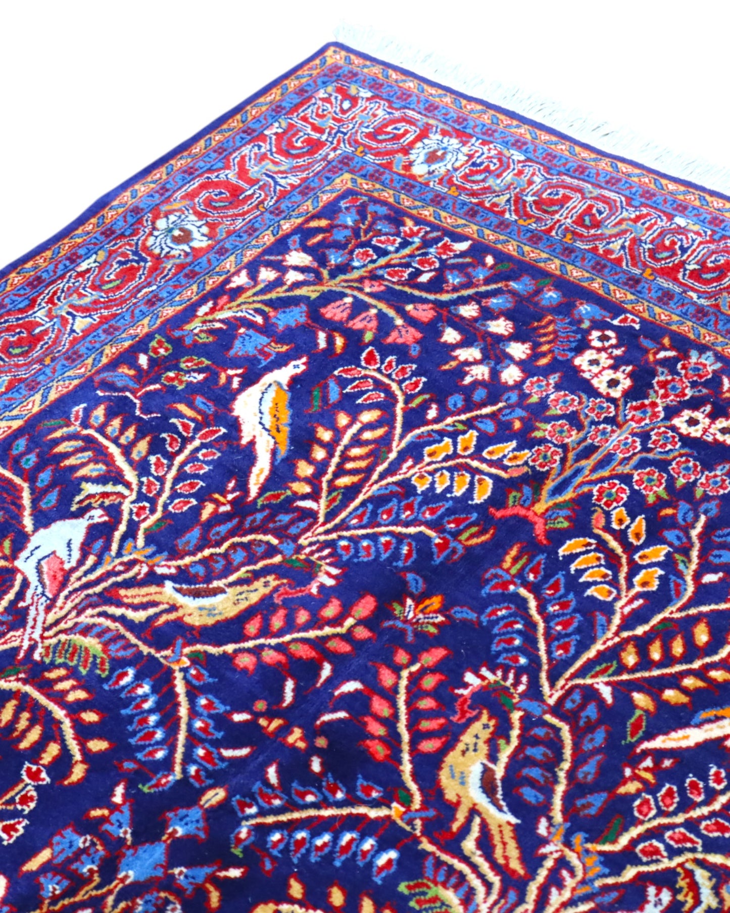 Tappeto Arak 210x126 cm persiano annodato a mano, con motivi floreali e animali su fondo blu intenso e cornice rossa decorata.