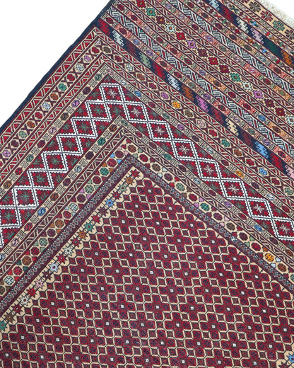 Tappeto Sumakh 184x126 cm con fondo bordeaux e motivi geometrici multicolori, annodato a mano, tradizione caucasica.